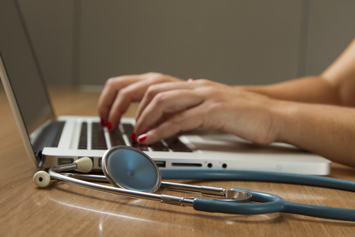 Physician reviewing ancillary services for medical practices on a laptop