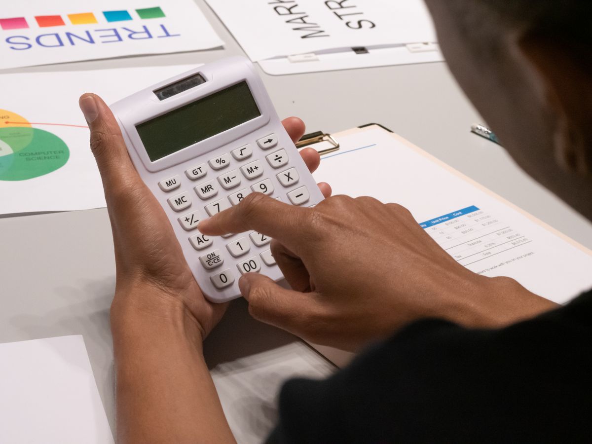 Practice owner running the direct primary care membership math on a calculator