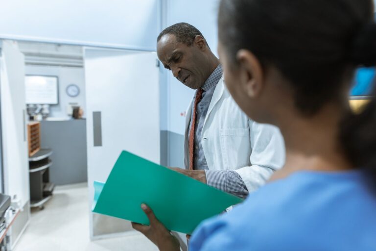 Medical practice team reviewing management services organization documents in a clinic office