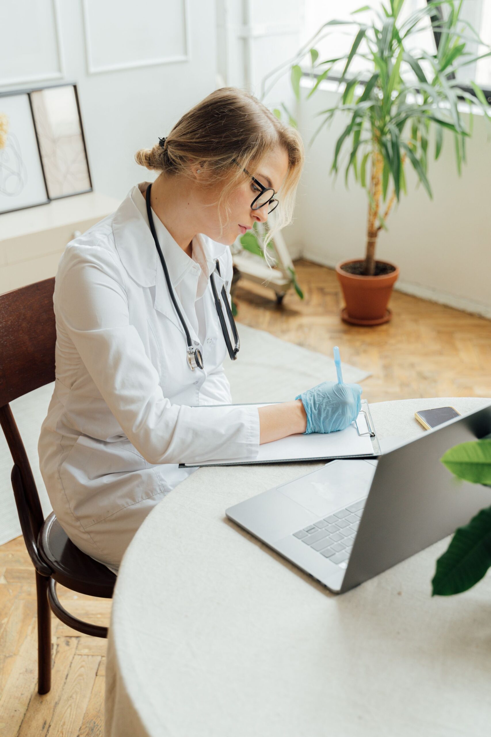 Physician completing a Medicare provider enrollment application at a medical practice desk